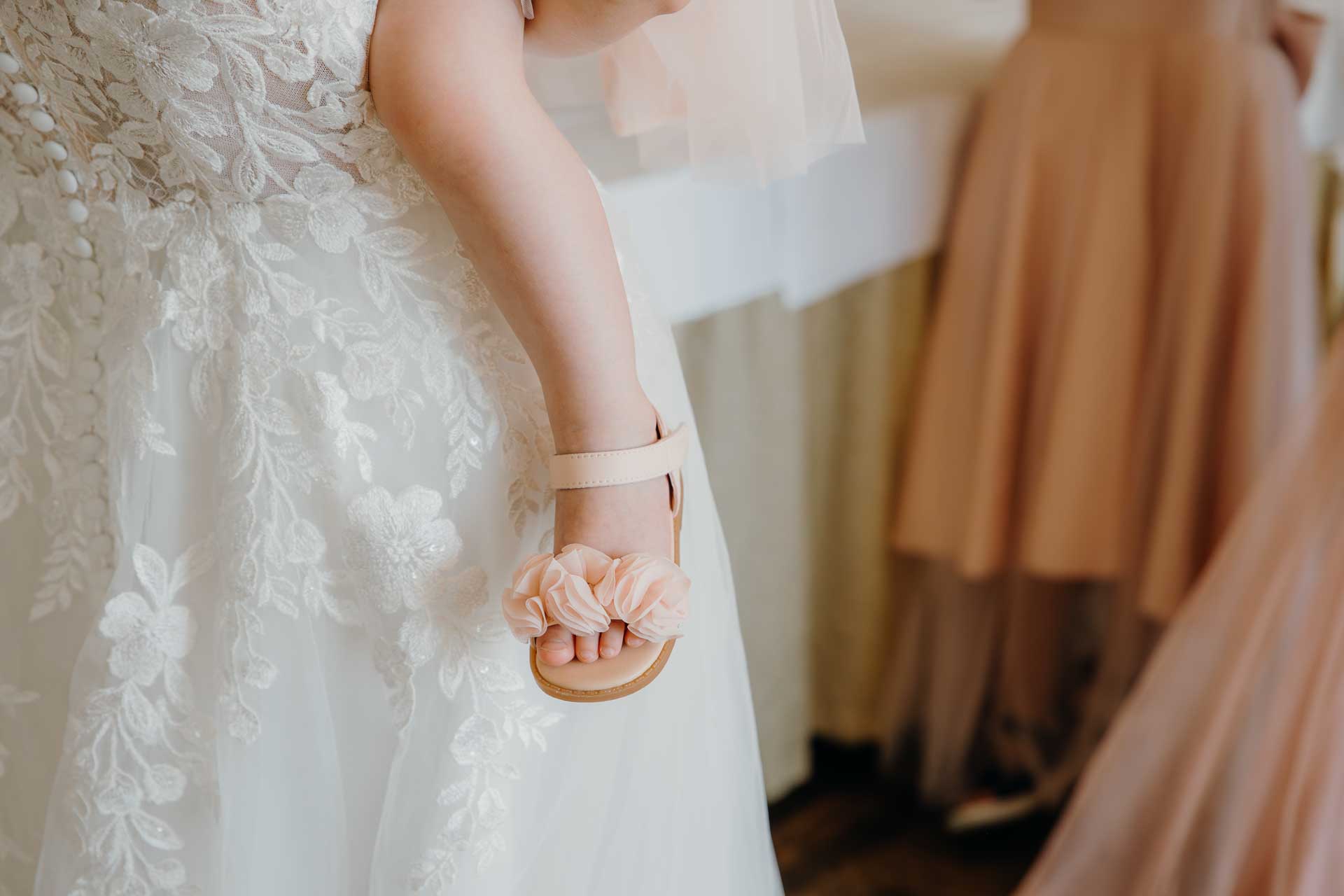 Nærbillede af bryllupsdetaljer, herunder de elegante invitationer, brudens glitrende smykker og gommens manchetknapper, alt sammen lagt omhyggeligt frem.
